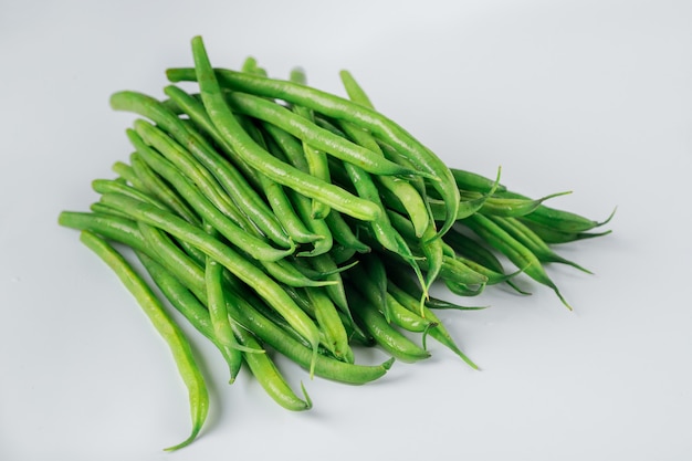 Tas de haricots longs verts isolés sur fond blanc