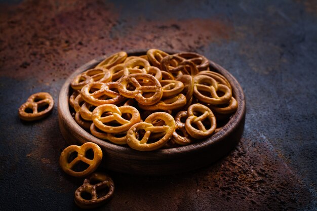 Tas de mini bretzels sur plaque de bois