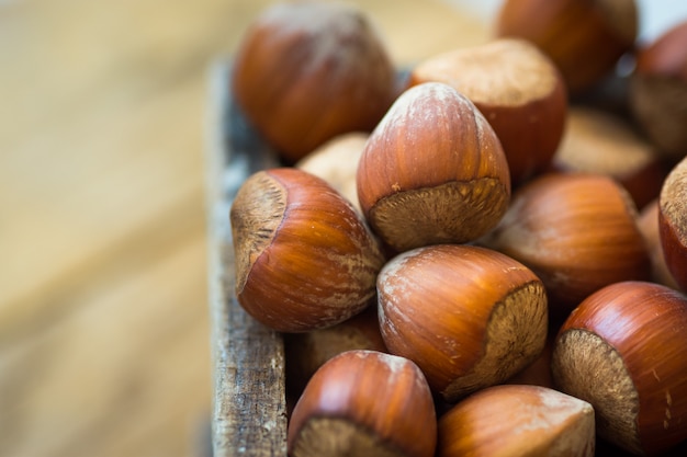 Tas de noisettes entières dans une boîte en bois sur une table de jardin