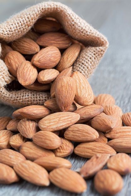 Tas De Noix D'amandes Dans Un Sac De Sac Sur Un Fond En Bois