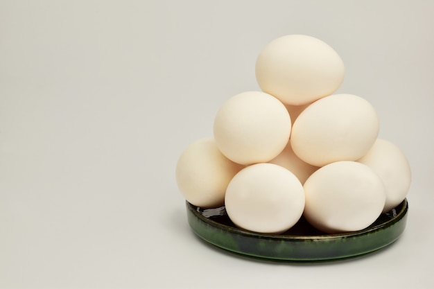 Un tas d'œufs de poule se trouve dans une soucoupe en céramique Il y a une place sur la gauche pour une inscription