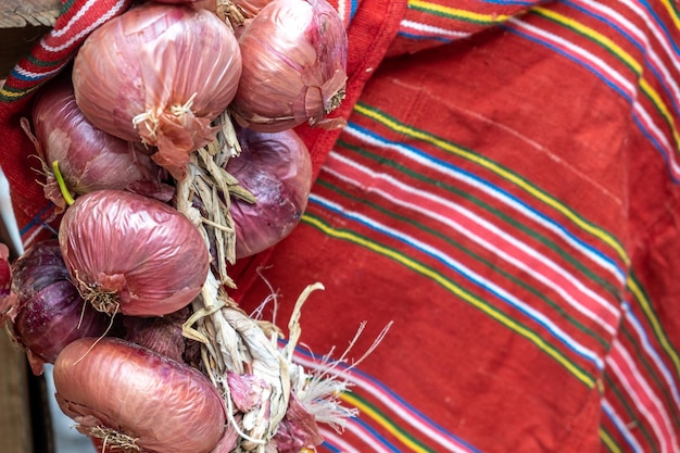 Photo un tas d'oignons sont sur un tissu rouge