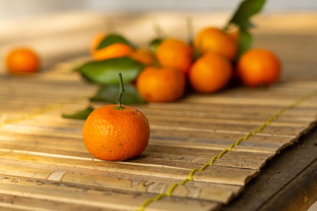 Photo un tas d'oranges avec des feuilles vertes sur une table en bois