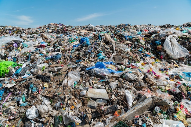 Un tas d'ordures dans une décharge contre un ciel bleu Déchets plastiques dans une décharge