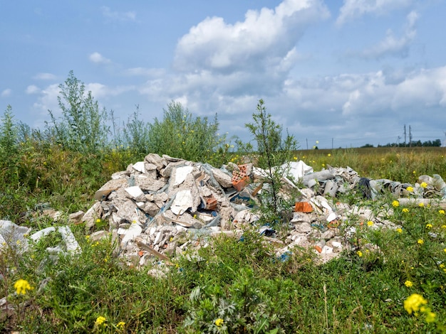 Photo tas d'ordures déversé sur le champ vert