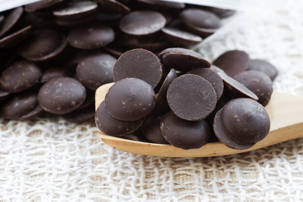 Tas de pépites de chocolat noir sur une cuillère en bois avec gros plan