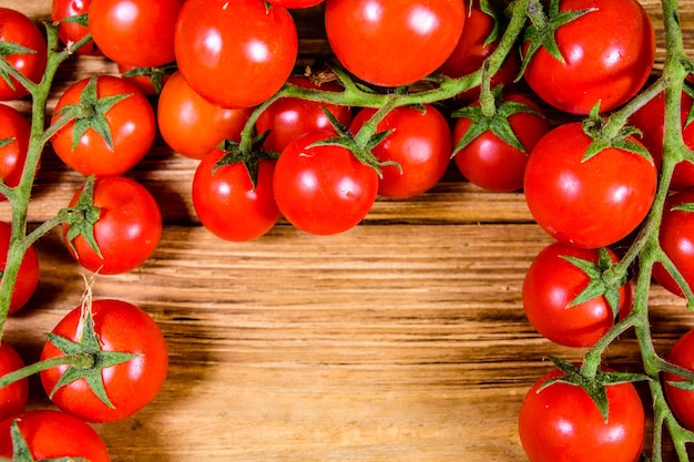 Tas de petites tomates cerises sur table en bois rustique. Vue de dessus