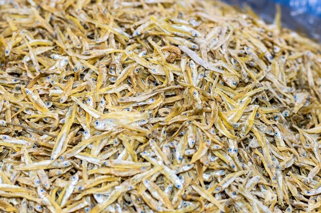 Un tas de petits poissons bruns séchés à l'intérieur d'un marché de fruits de mer