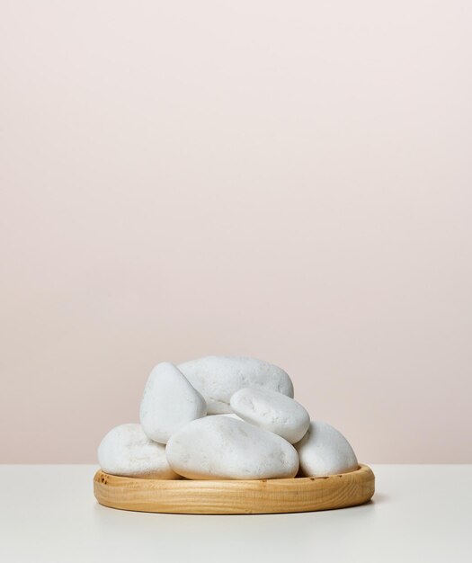 Un tas de pierres blanches rondes sur un support en bois une scène pour afficher les produits