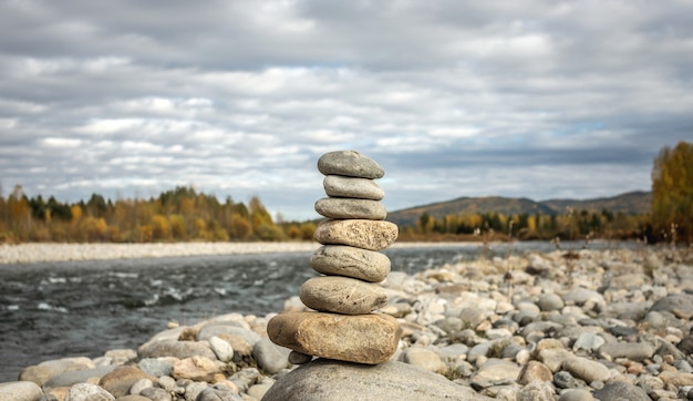 Tas de pierres construit en cairn sur le fond de la rivière. Calme et détachement avec la nature