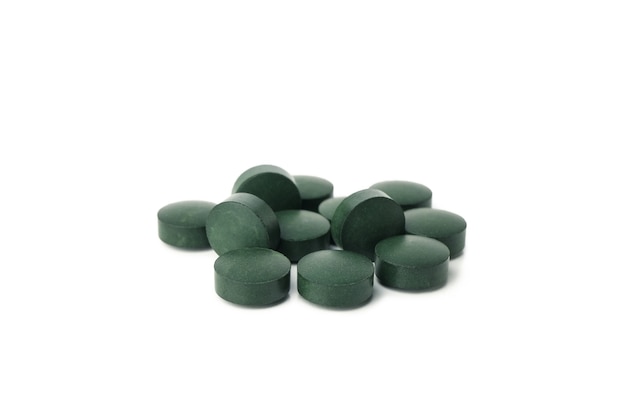 Tas de pilules de spiruline isolé sur fond blanc