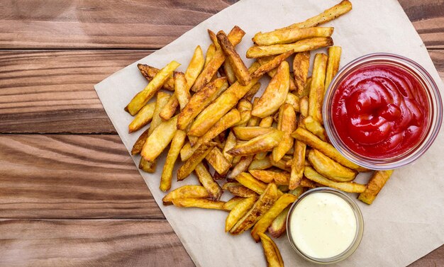 Tas de pommes de terre frites avec des sauces sur la table Vue de dessus