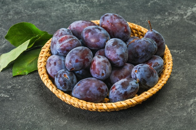 Tas de prunes mûres dans le panier