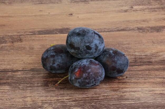 Tas de prunes mûres sur fond