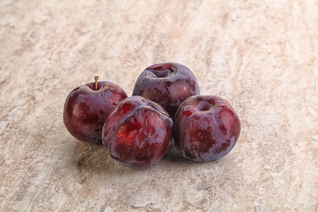 Tas de prunes violettes mûres et sucrées sur fond