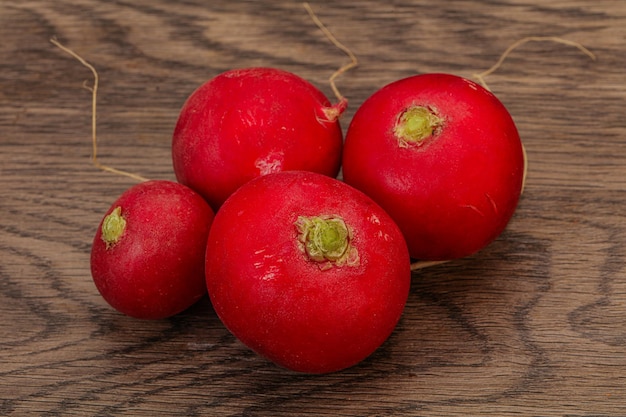 Tas de radis frais mûrs sur fond de bois