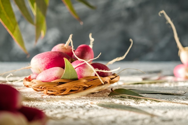 un tas de radis maison se trouve sur la table des légumes rouges et verts sur fond clair