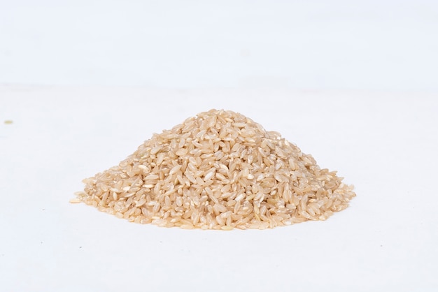 Tas de riz brun sur une surface blanche