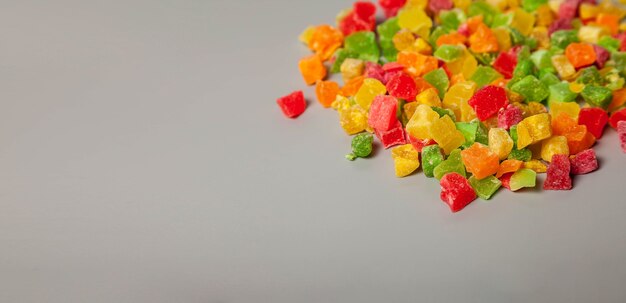 Tas de tas d'ananas séchés se bouchent sur fond gris. Macro photo alimentaire Cubes d'ananas séchés. Morceaux de fond de texture couleur ananas. Image produit alimentaire pour la cuisson de la bouillie. Espace de copie