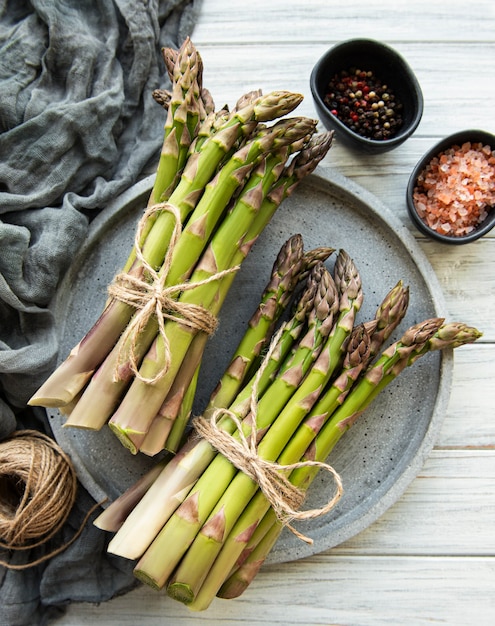 Tas de tiges d'asperges crues sur bois