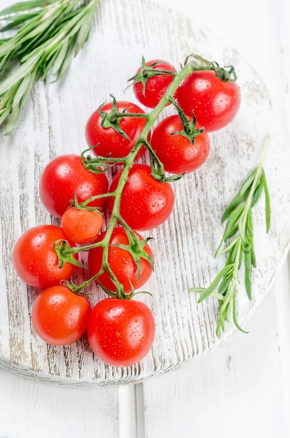 Tas de tomates cerises rouges bio juteuses au romarin vert