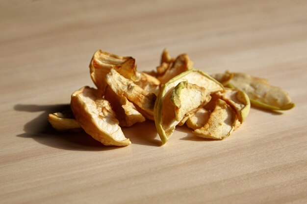 Tas de tranches de pommes séchées chips de fruits sur table en bois