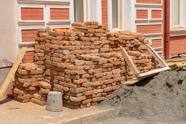 Photo des tas de vieilles briques de construction rouges éparpillées dans la rue. imeuble