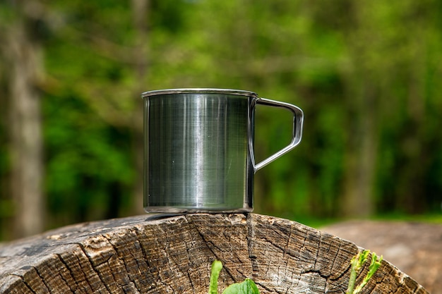 Tasse en acier touristique dans la forêt d'été à l'extérieur