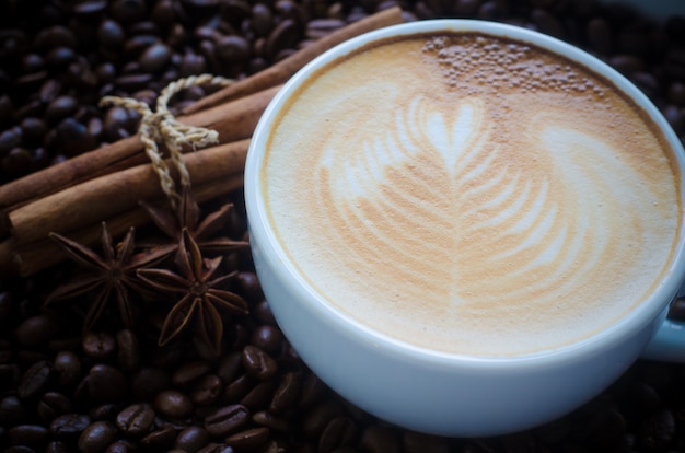 Une tasse d&#39;art latte sur fond de grain de café