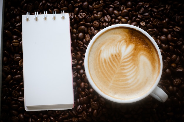 Une tasse d&#39;art latte sur fond de grain de café