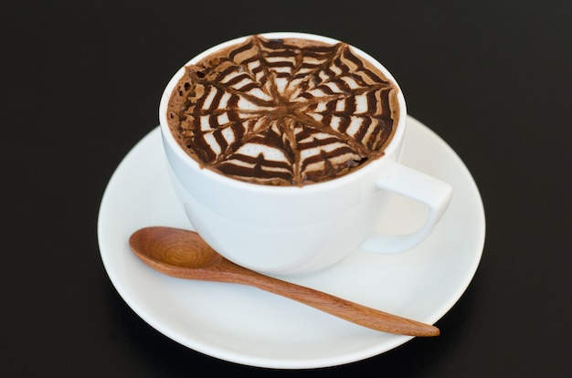 Une tasse d&#39;art latte sur fond noir