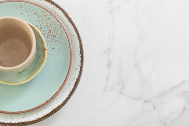 Tasse et assiette en céramique sur table en marbre blanc