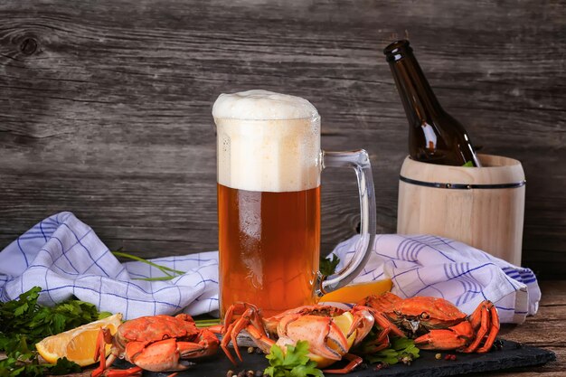 Photo une tasse de bière avec des crabes sur une surface en bois