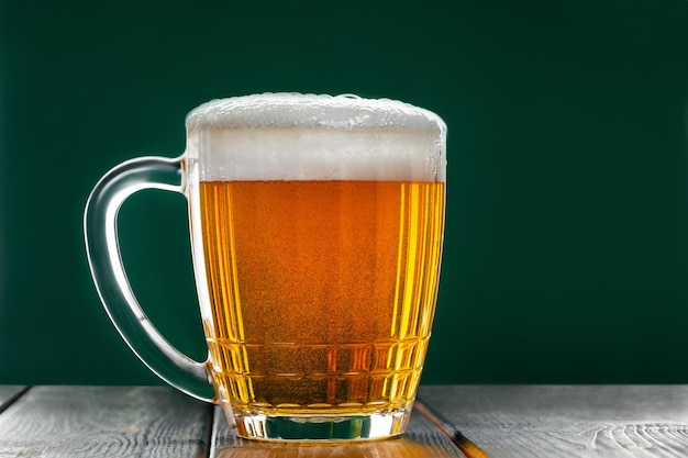 Photo une tasse avec de la bière irlandaise traditionnelle sur un fond vert foncé des bulles dans un verre de bière