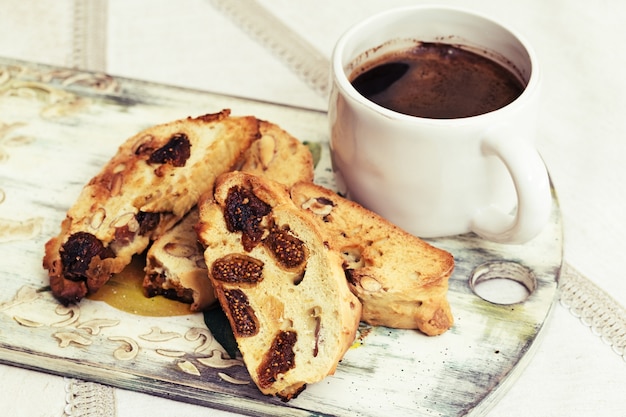 Tasse de biscotti au café noir et biscuits faits maison sur une nappe en lin.