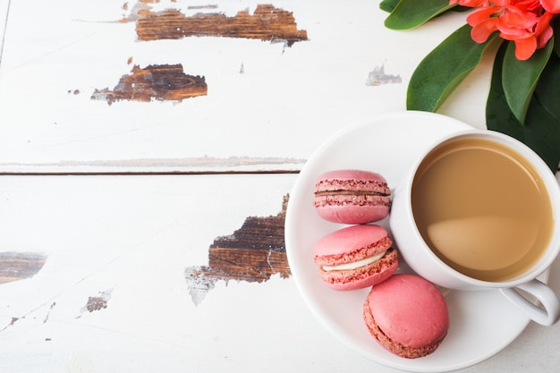 Tasse de biscuits au café et macaron sur une assiette sur un fond blanc. espace de copie
