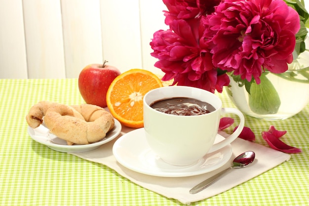 Tasse de biscuits au chocolat chaud à l'orange et aux fleurs sur la table du café