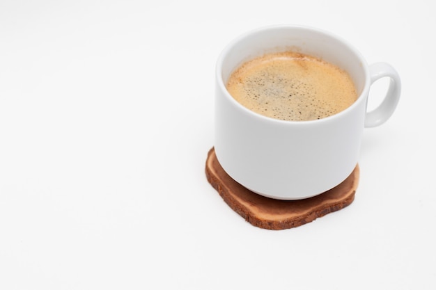 Tasse blanche avec café americano noir frais sur cercle en bois coupé.