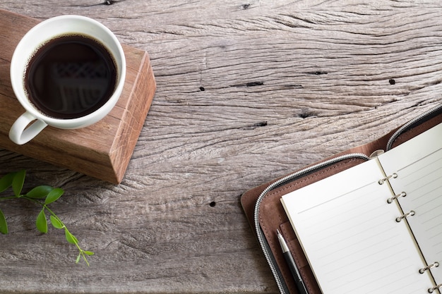 tasse blanche café avec carnet de notes sur table en bois