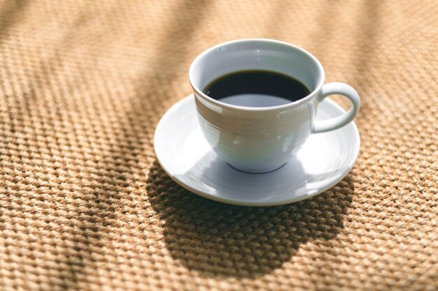 Une tasse blanche de café chaud sur la moquette