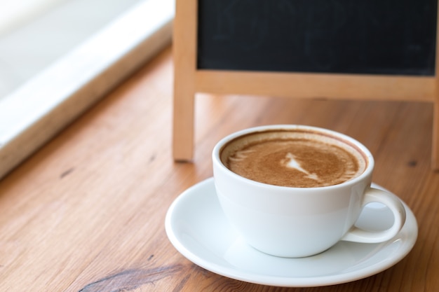 Une tasse blanche de café chaud sur la table en bois