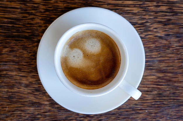 Tasse blanche de café frais sur la vue de dessus de table en bois