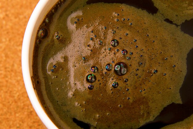 Tasse blanche de café noir chaud sur une table en liège agrandi. boissons chaudes