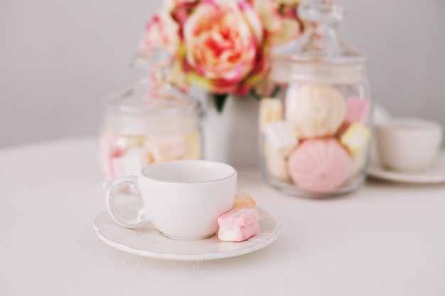 Tasse blanche avec des guimauves sur fond blanc. Petit déjeuner romantique. Concept de vacances, anniversaire, Pâques, 14 février, 8 mars. pose à plat