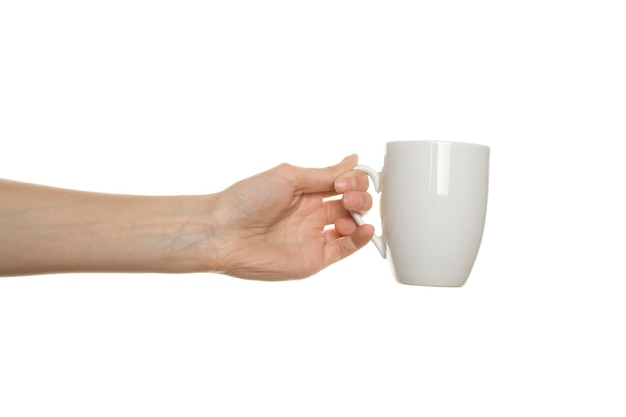 Tasse blanche à la main isolé sur fond blanc