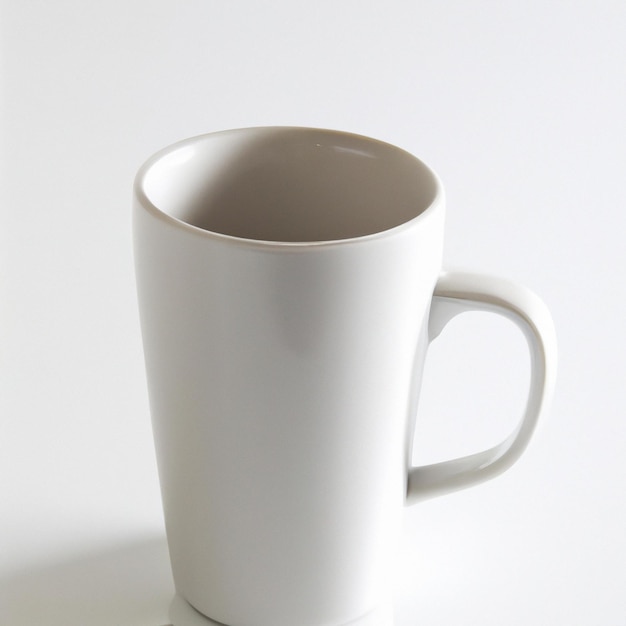 Une tasse blanche avec une poignée debout sur un fond blanc