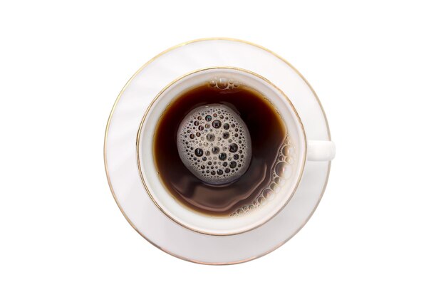 Une tasse blanche sur une soucoupe blanche avec du café noir sur un fond blanc