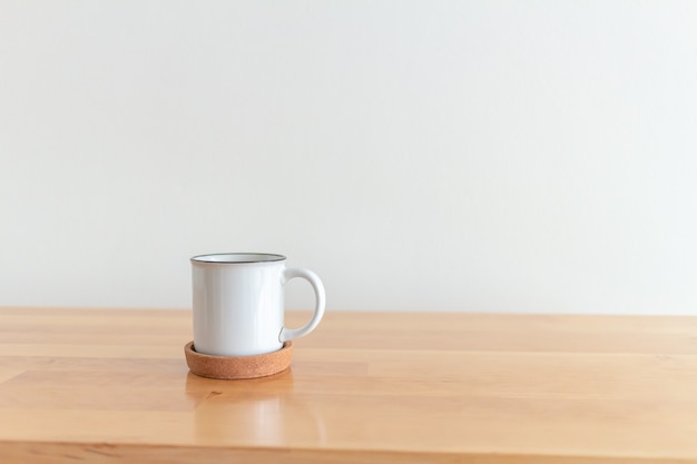 Tasse blanche de tasse de café chaud sur la table en bois avec le fond blanc