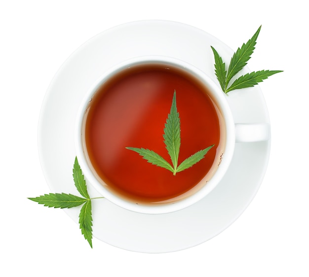 Tasse blanche avec thé et feuilles de cannabis sur fond blanc isolé, vue de dessus