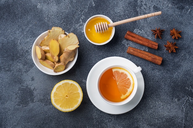 Tasse blanche avec tisane naturelle au gingembre, citron et miel à la cannelle.